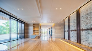 A modern hotel lobby with a wooden floor, glass doors, a reception desk, and a cityscape view. - Holiday Inn Zhuhai City Center (Zhuhai)