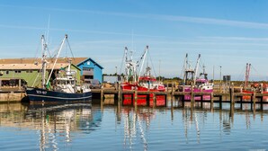 A harbor with several fishing boats docked at wooden piers. - First Camp Lakolk strand- Römö (Rømø)