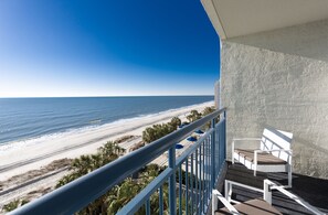 Un balcon avec vue sur la plage et l’océan.