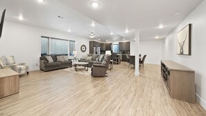 A spacious living area with a modern kitchen, a dining area, and a seating area with sofas and a coffee table. - Brand new, 3 Bedroom Suite in Fort Morgan! (Fort Morgan)