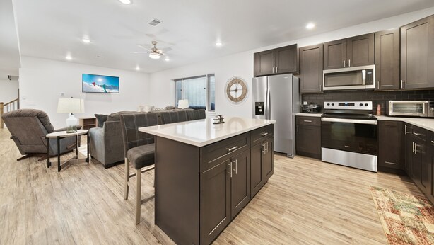 A modern kitchen with dark cabinets, stainless steel appliances, and a central island. - Brand new, 3 Bedroom Suite in Fort Morgan! (Fort Morgan)