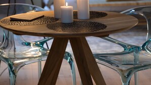 Una habitación de hotel acogedora con una cama, lámparas de noche y una mesita con velas.