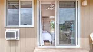 A room with a bed, a ceiling fan, and a sliding glass door leading to a balcony. - 435 East Lake (Montauk)