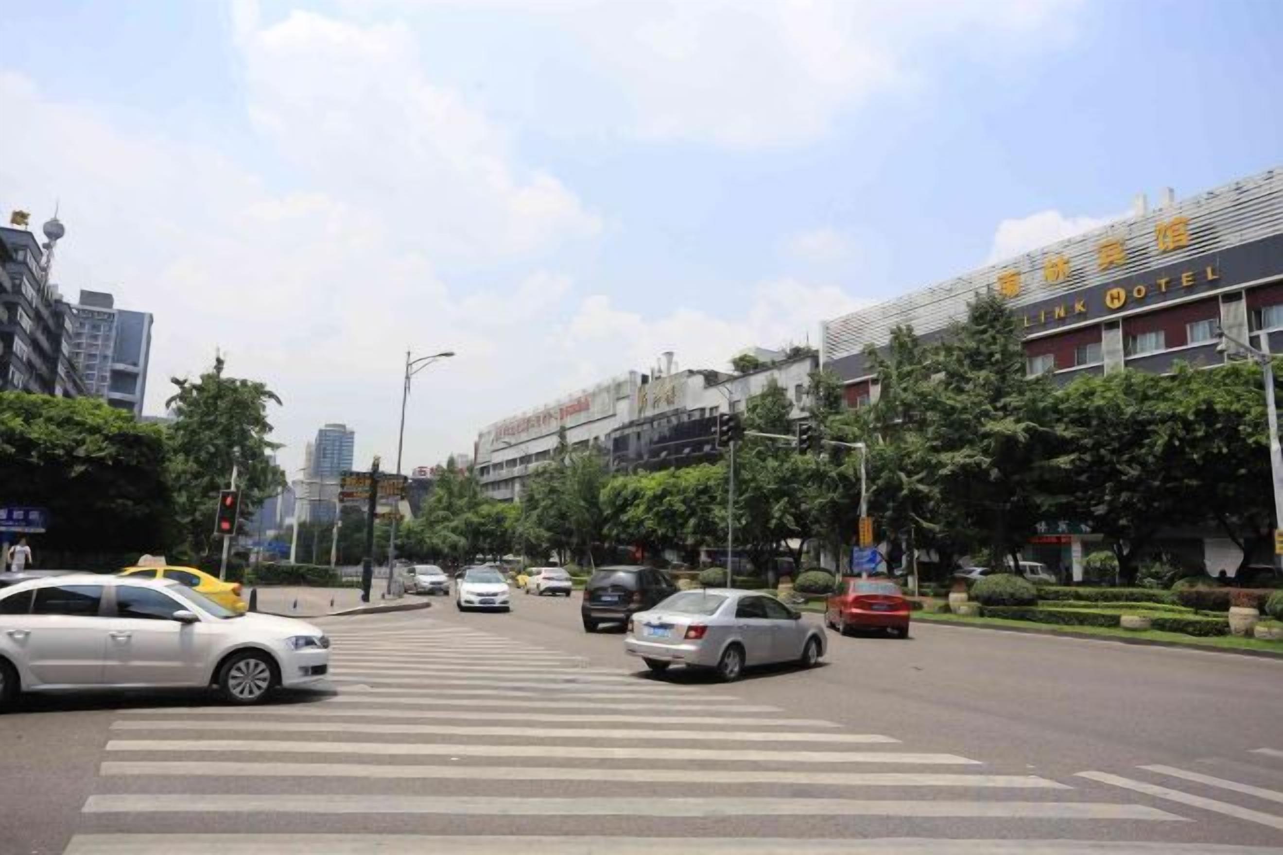 A busy urban street with a hotel named 'LINK HOTEL' on the right.
