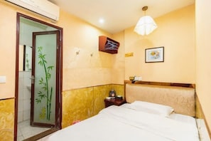 A hotel room with a bed, a nightstand, a wall-mounted shelf, a door with a bamboo design, and a ceiling light. - Chongqing Yuanjing Hotel (Xietaizi Metro Station Keyuan 4th Road Branch) (Chongqing)