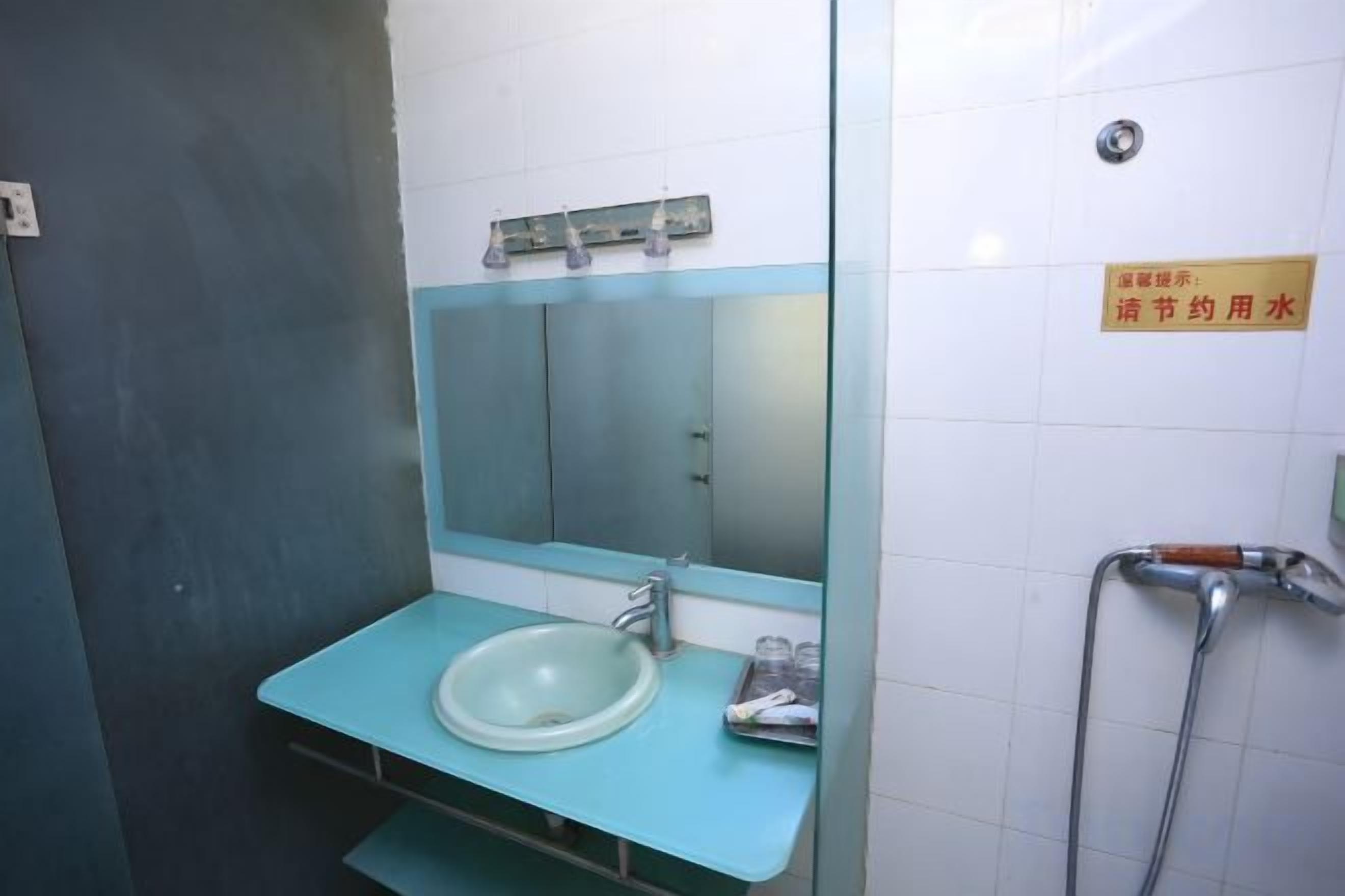 Een badkamer met een wastafel, spiegel en een handdroger.