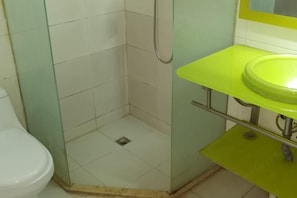 A bathroom with a shower, a toilet, and a green sink. - Chongqing Yuanjing Hotel (Xietaizi Metro Station Keyuan 4th Road Branch) (Chongqing)