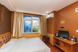 A hotel room with a bed, a TV, a small table, and an air conditioning unit. - Chongqing Yuanjing Hotel (Xietaizi Metro Station Keyuan 4th Road Branch) (Chongqing)