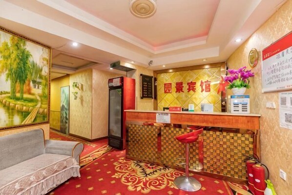 A reception area with a check-in counter, a sofa, and a decorative wall with a painting. - Chongqing Yuanjing Hotel (Xietaizi Metro Station Keyuan 4th Road Branch) (Chongqing)