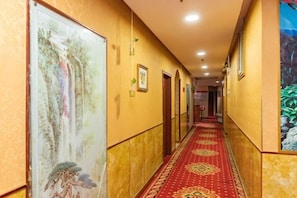 A hotel corridor with a red carpet, framed artwork on the walls, and doors leading to rooms. - Chongqing Yuanjing Hotel (Xietaizi Metro Station Keyuan 4th Road Branch) (Chongqing)