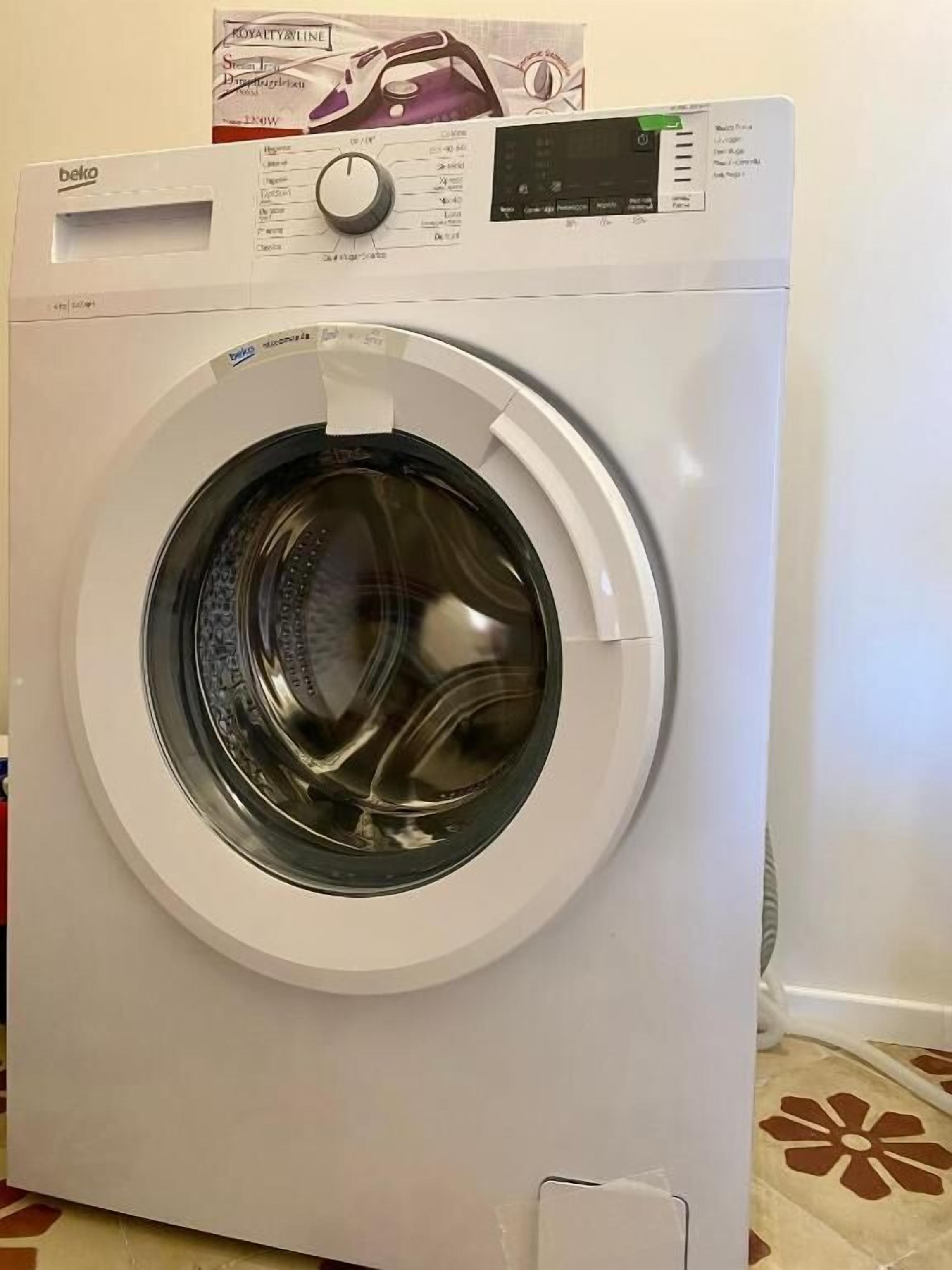 A front view of a white front-loading washing machine with a control panel and a circular door.