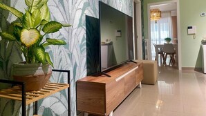 A modern living room with a flat-screen TV, wooden console, and a potted plant. - Bella Luna Apulian Living (Monopoli)