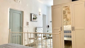 A bedroom with a bed, a chair, a wardrobe, and a television. - Shell (Monopoli)