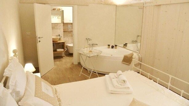 A hotel bathroom with a bathtub, a sink, and a mirror. - Vitti Suite 5 (Monopoli)