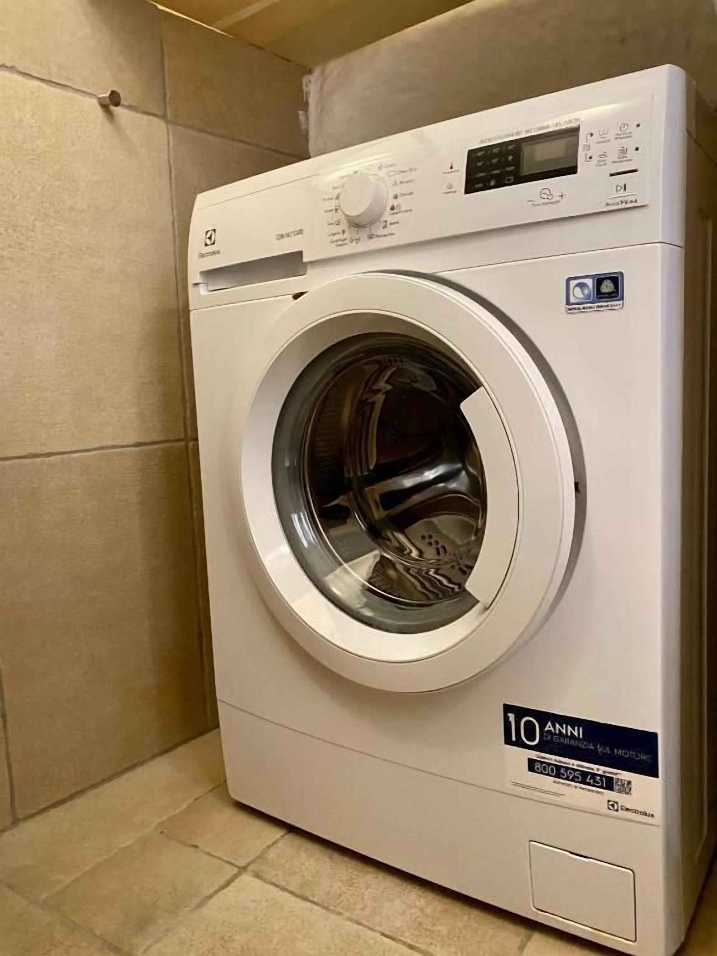 A front-loading washing machine with a digital display and control panel.