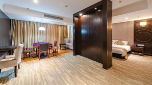 A hotel room with a wooden floor, a bed with a headboard, a desk with chairs, a dining table, and a large window with curtains. - Dongfang Haomen Wangting Boutique Hotel (Huzhou)