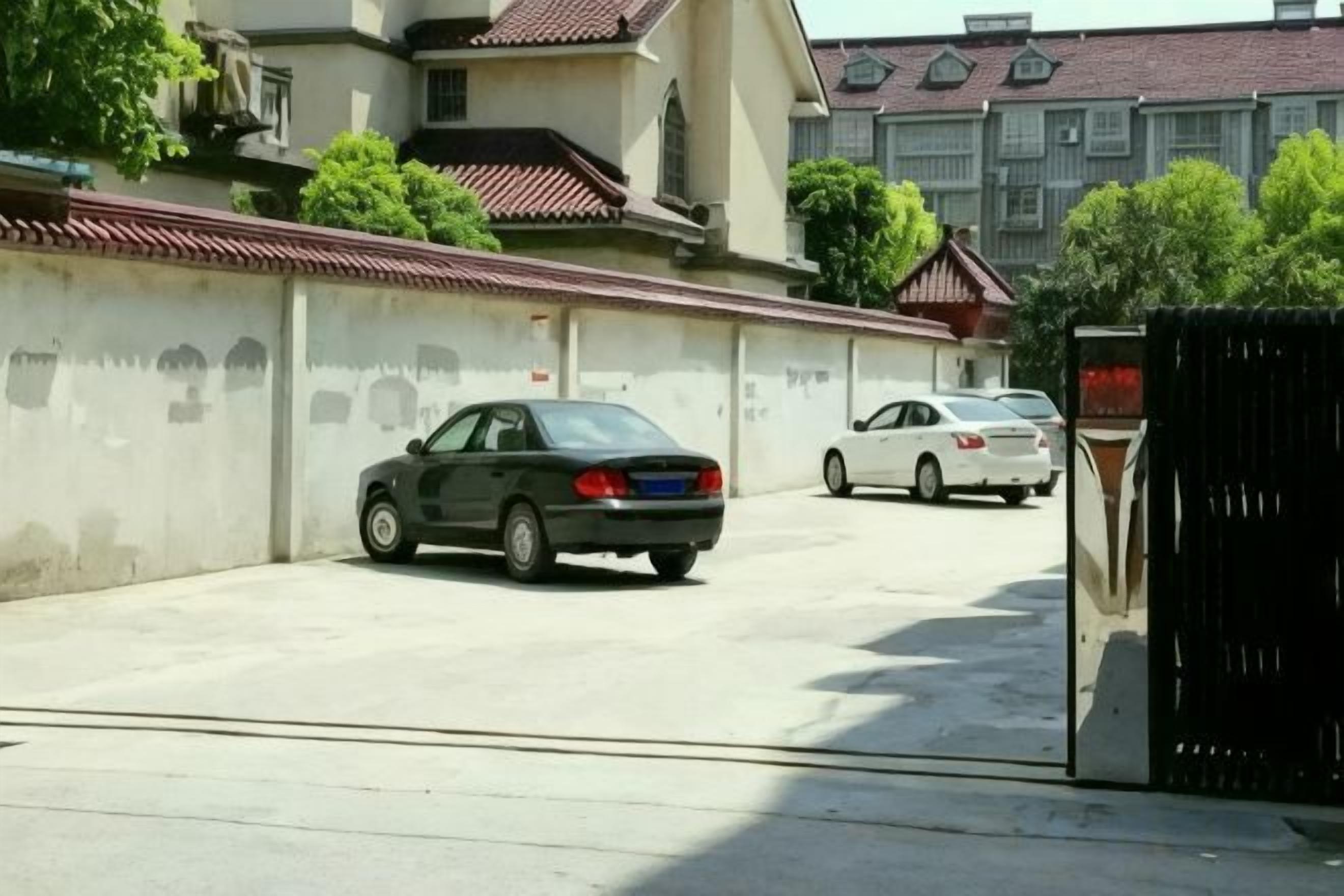 Ein Parkplatz mit einem Auto und einem Tor.