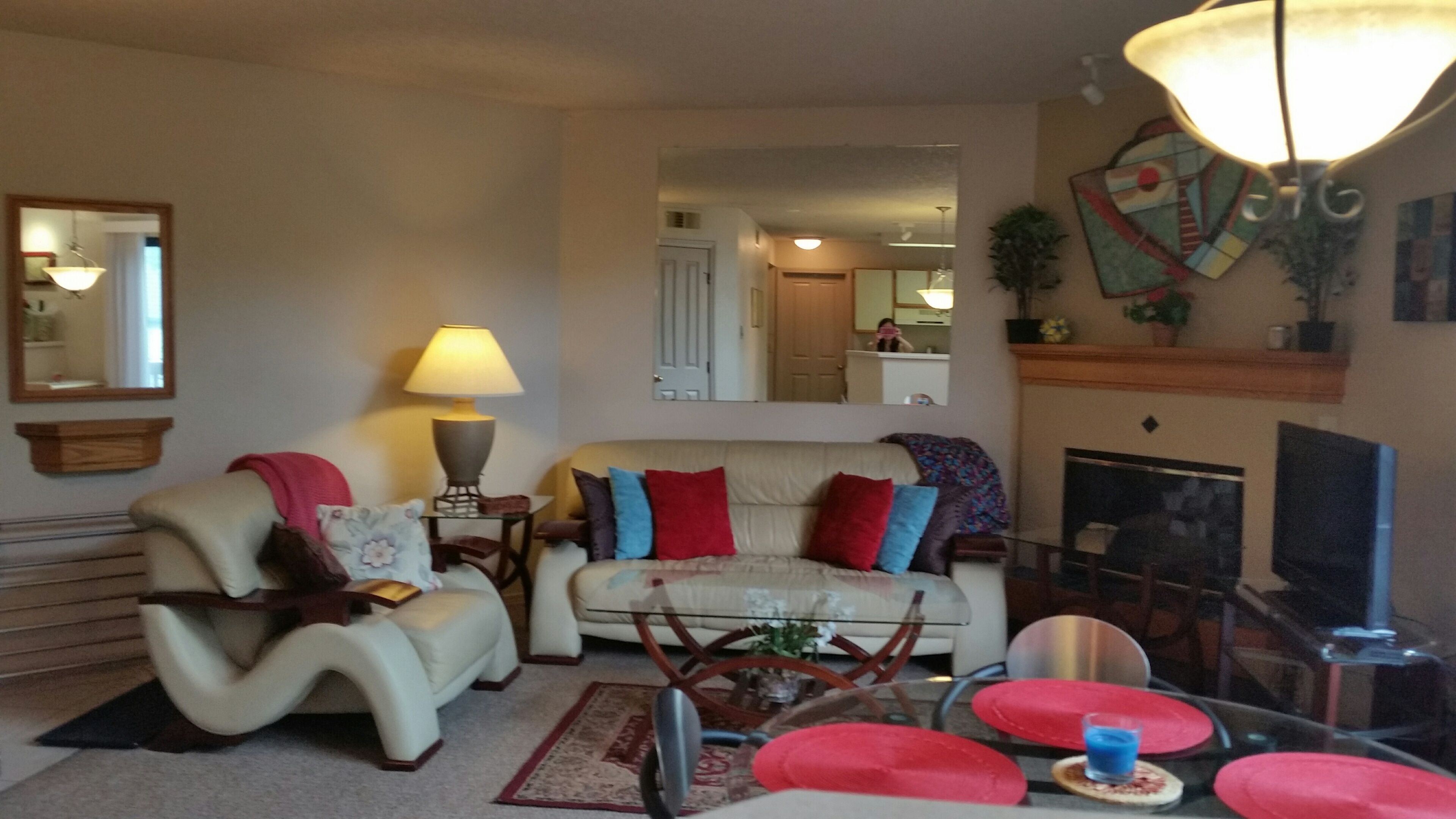 Una sala de estar con un sofá, sillones, una mesa de centro y una chimenea.