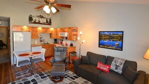 A compact living space with a kitchenette, a dining area, and a seating area with a couch and chairs.
