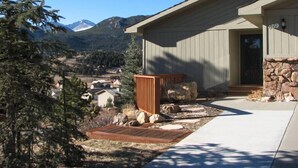 A modern house with a stone foundation, a wooden deck, and a view of mountains. - Twin Sisters - 2 bedroom 2 bathroom townhouse (Estes Park)