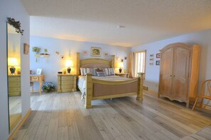 Comfortable bedroom with a large bed, bedside tables, and a wardrobe.