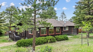 A cabin with a wooden exterior, a satellite dish, and a small porch. - Elk Run - 2 bedroom cabin- near RMNP (Estes Park)