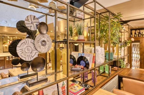 Un expositor de vidrio con vajilla, libros y objetos decorativos.
