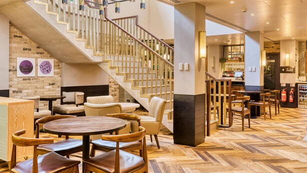 A hotel lobby with a staircase, seating area, and a bar. - Hub By Premier Inn London Camden (London)