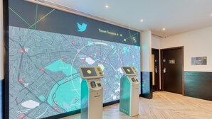 A digital map display with two self-service kiosks in a lobby. - Hub By Premier Inn London Camden (London)