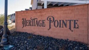 A brick wall with the words "Heritage Pointe" in large, decorative lettering.