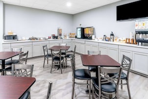 A modern kitchen with white cabinets, stainless steel appliances, and a flat-screen TV mounted above the counter.
