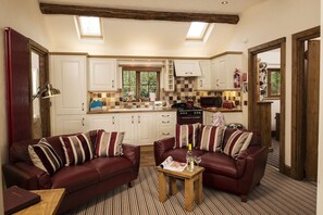 Relax in this inviting living area with two sofas and a kitchen featuring white cabinets and a checkered backsplash.