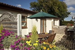 Enjoy a peaceful retreat with a patio area featuring a table, chairs, and lush plants.