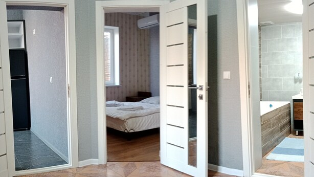 A room with a bed, a bathroom with a bathtub, and a kitchen area. - House4you (Tashkent)