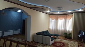 A living room with a sofa, a television, and a patterned rug. - House4you (Tashkent)