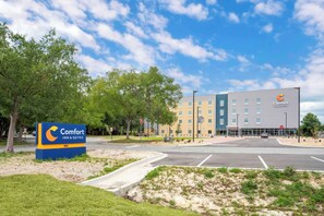 A Comfort Inn & Suites hotel with a parking lot and a building with multiple floors and windows.