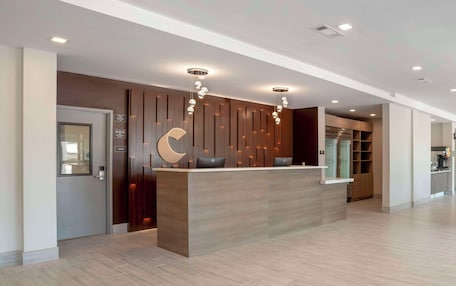 A modern reception desk with a wooden finish, a large crescent moon decoration, and pendant lighting.
