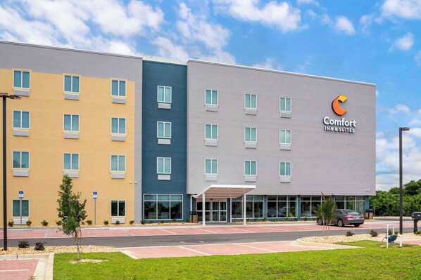 A multi-story hotel with a modern design, featuring a prominent Comfort Inn & Suites sign.