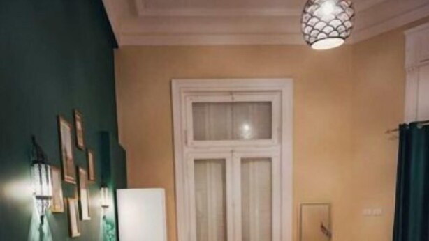 A bedroom with a bed, bedside table, and a hanging light fixture. - Cozy 1 bedroom Queen and single bed 2 (Cairo Governorate)
