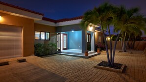 Una casa moderna con garage, ingresso coperto e vialetto lastricato.