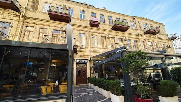 A hotel with a classic facade, large windows, and a modern glass entrance. - Solo Hotel  (Baku)