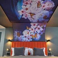Un dormitorio con una cama grande, dos almohadas, un cabecero y dos lámparas de pared.