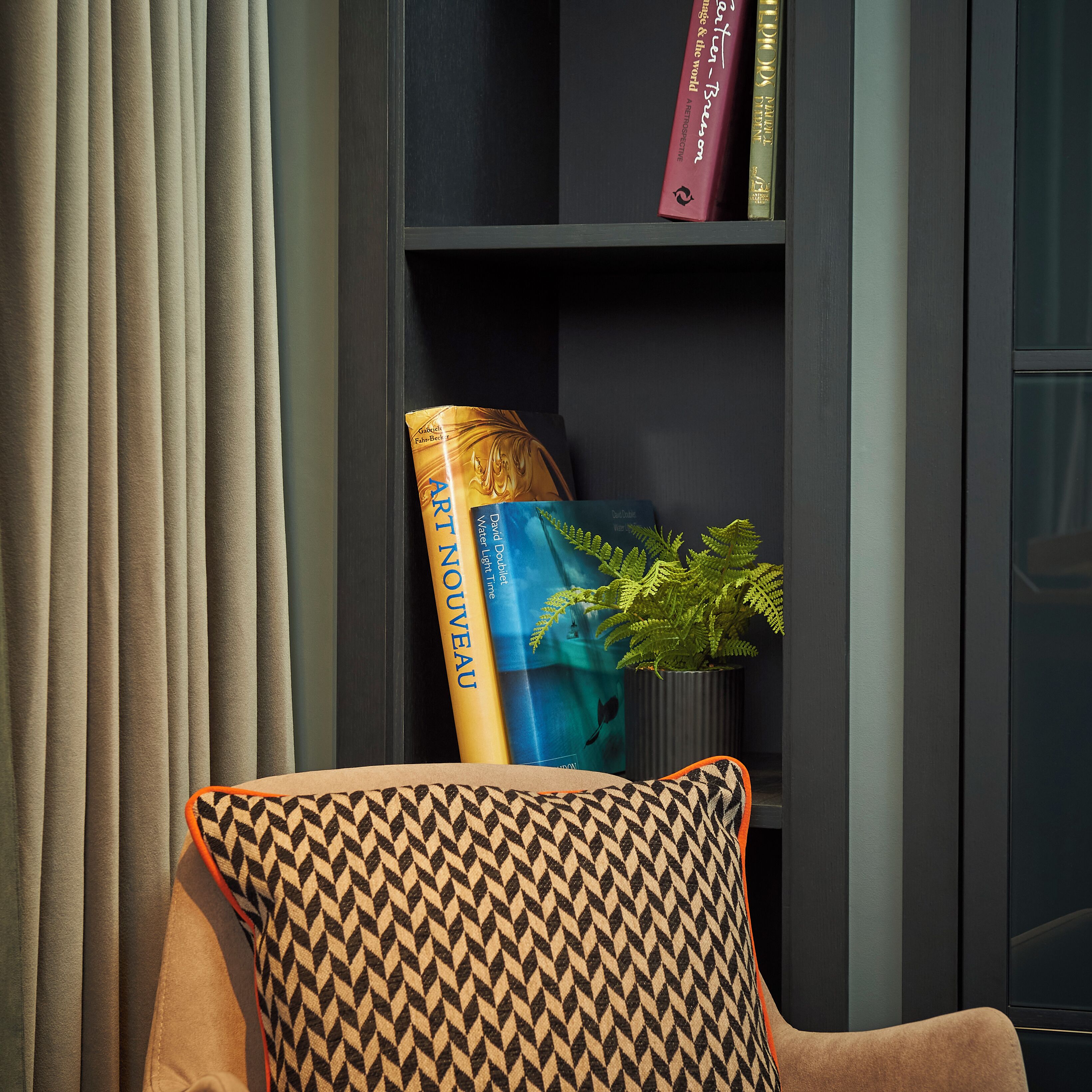 A bookshelf with books and a potted plant.
