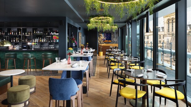 A modern restaurant with a bar area, wooden flooring, and large windows offering city views. - Malmaison Manchester Deansgate  (Manchester)