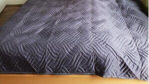 Un dormitorio con una cama, dos almohadas y dos adornos con forma de corazón en la pared.