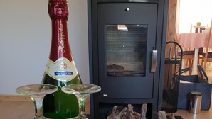 Una botella de cerveza Polkapp, cuatro vasos y una estructura de madera decorativa en una habitación con chimenea.