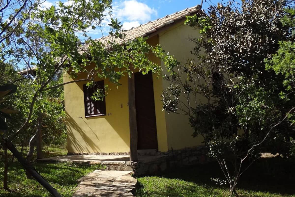 A yellow building with a stone pathway leading to a dark door.