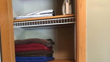 A wooden shelf unit with folded towels in various colors.