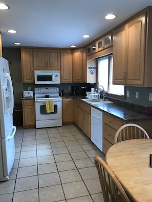 Enjoy cooking in this well-equipped kitchen with a refrigerator, microwave, oven, dishwasher, and sink.