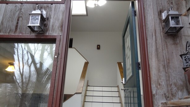 A wooden staircase with white steps leading to a landing.